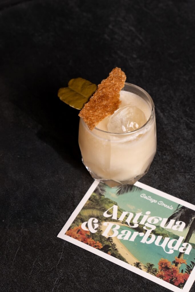 Postal de Antigua Barbuda con el cóctel Collage Creole del P41 del Hotel Arts, ilustración vintage y tipografía única.