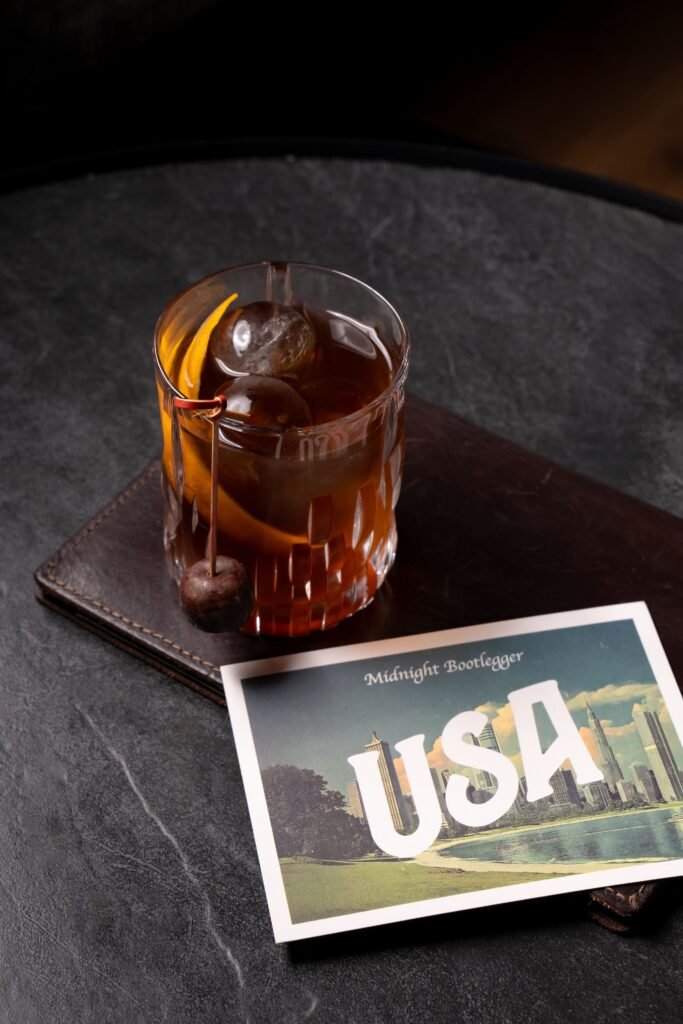 Postal de Estados Unidos con el cóctel Midnight Bootleger del P41 del Hotel Arts, ilustración vintage y tipografía única.